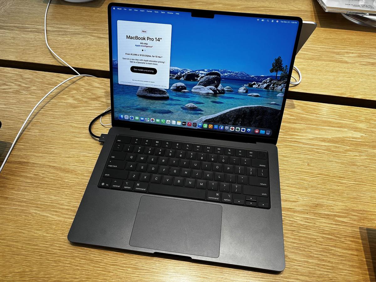 Černý MacBook Pro s čipem Apple M5 na dřevěném stole