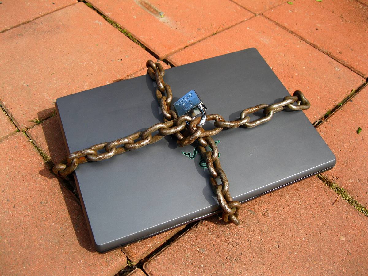 Notebook obtočený řetězem a uzamčený visacím zámkem